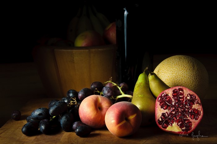 Still-life of fruits including peaches, grapes, pears, pomegranate, and melon