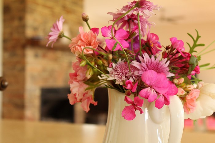 Bouquet of pink and coral flowers in a white pitcher