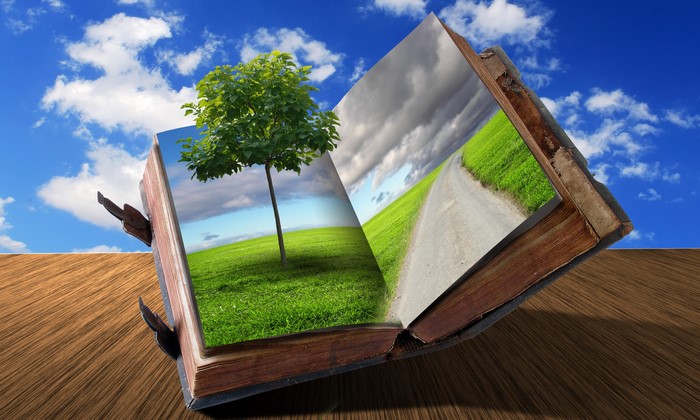 Open book with nature scenes against blue sky