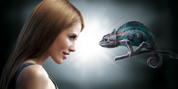 Woman looking at a chameleon on a branch