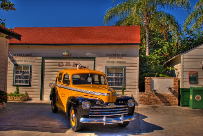 Yellow and black taxi in front of a building