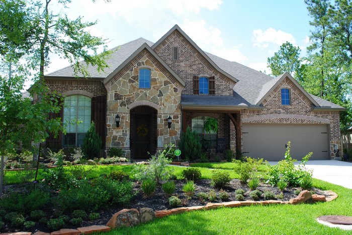 Brick and stone house with landscaping and garage