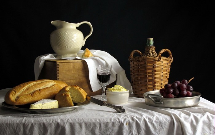 Still-life with bread, grapes, wine, and cheese