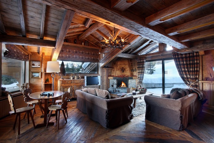 Cozy wooden living room with fireplace and snow view