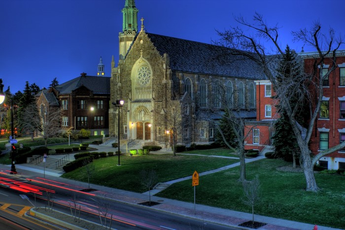 Church and buildings at night with light trails on road