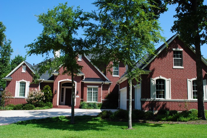 Red brick house with trees and lawn