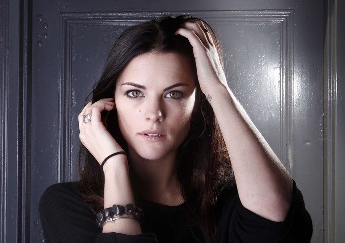 Jaimie Alexander with hands near face