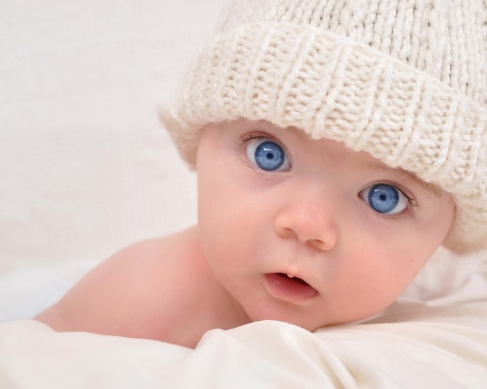 Baby with blue eyes wearing a knitted hat