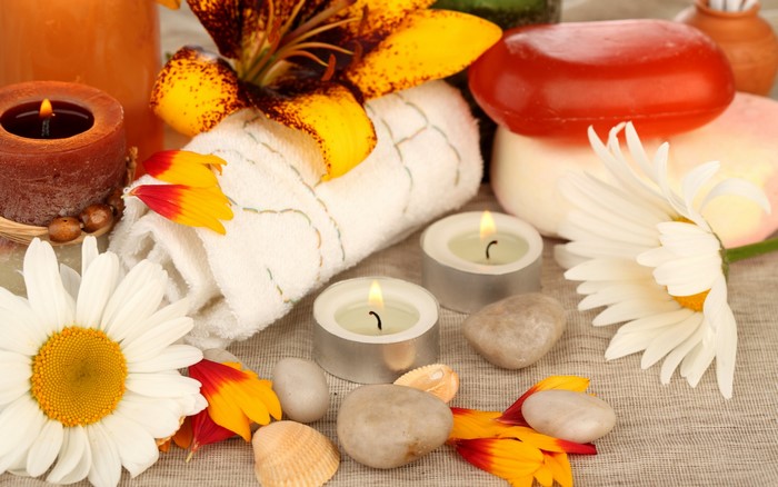 Spa arrangement with candles, flowers, soap, and towel