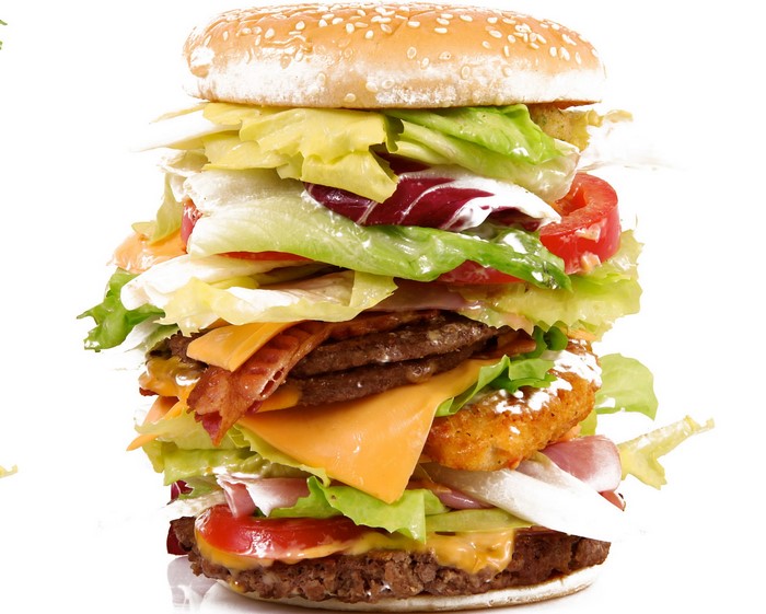 A very tall hamburger with multiple patties and toppings