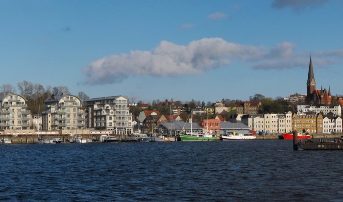 Waterfront cityscape with modern buildings and a church spire