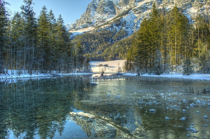 Winter landscape with snow-covered mountains and a frozen lake in Southern Bavaria, Germany