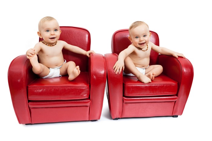 Two babies in red armchairs