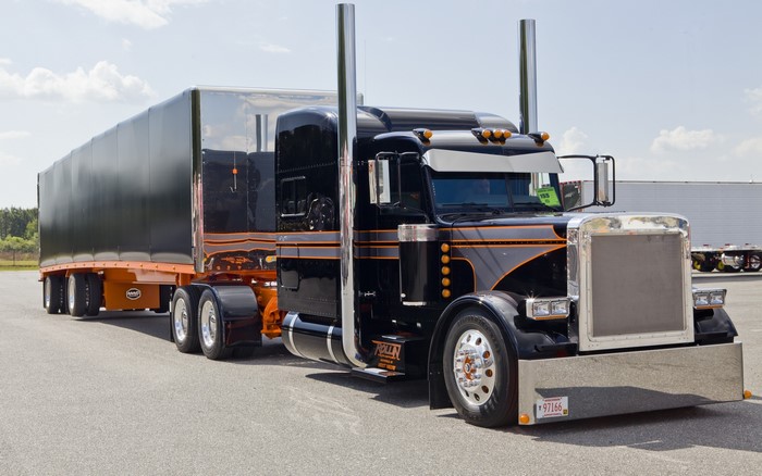 Black Peterbilt truck with trailer