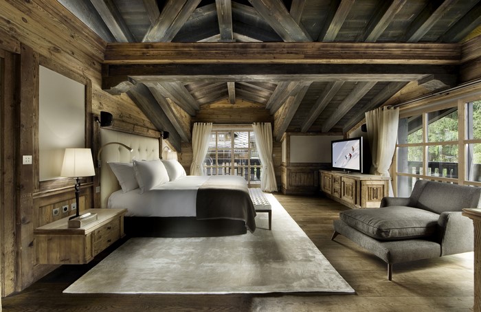 Rustic wooden bedroom with large bed and armchair