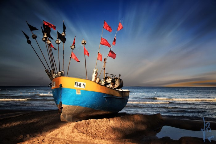 Fishing boat with flags on a beach