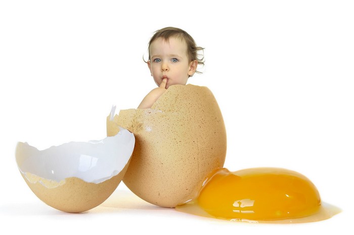 Baby emerging from a cracked egg with yolk
