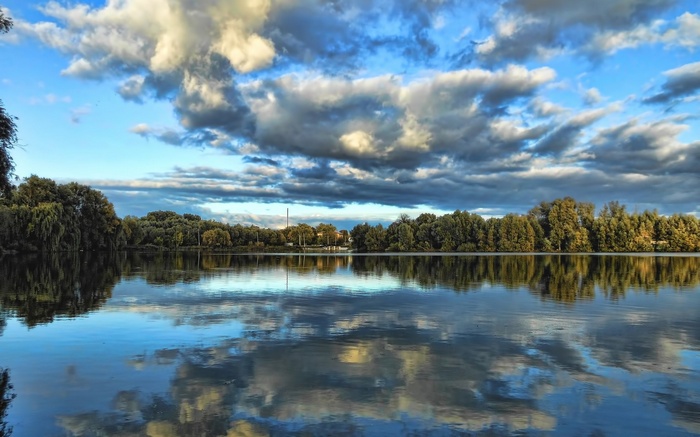 Lake with trees and cloudy sky reflection