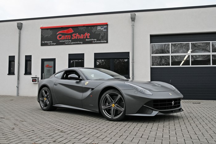 Matte Grey Ferrari F12berlinetta parked in front of Cam Shaft building