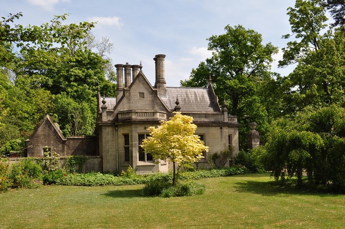 Old stone house with chimneys surrounded by trees