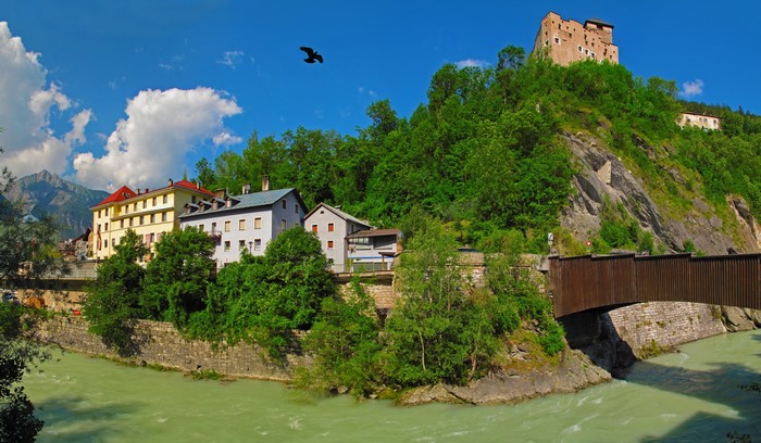 Castle on a hill above a river and town in Austria