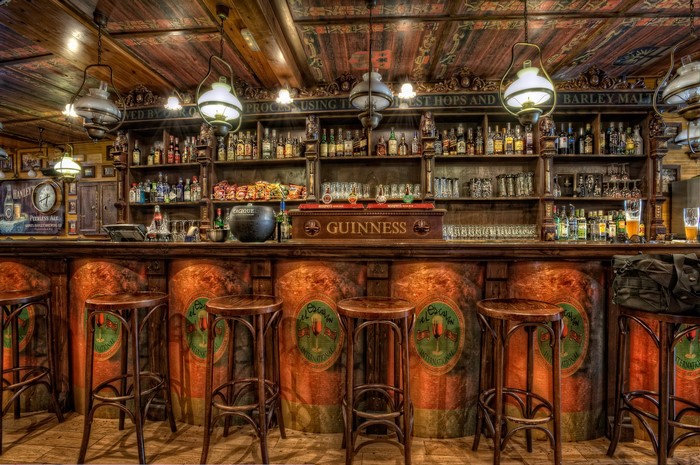 Interior of a traditional Irish pub with a wooden bar and stools