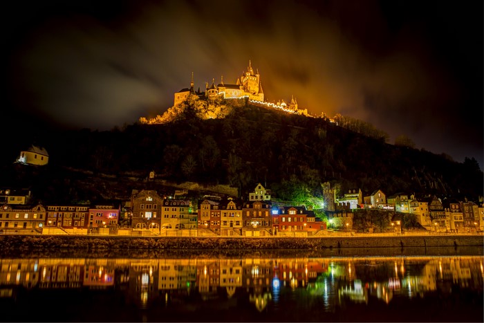 Cochem Castle and town at night with river reflection