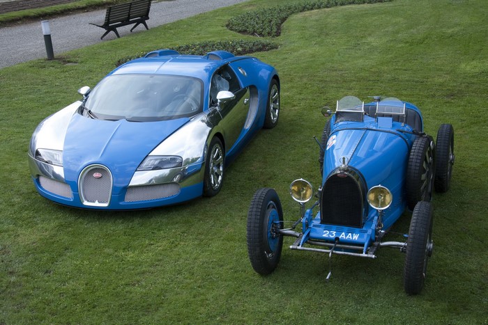Two Bugatti cars on a grassy lawn