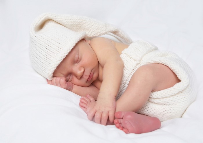 Newborn baby sleeping in a knitted outfit