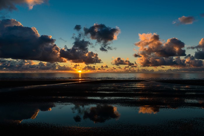 Sunset over the Sea with Clouds and Reflections