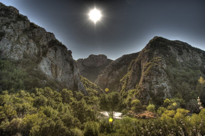 Sunlight shining over mountains and trees in Malibu, California