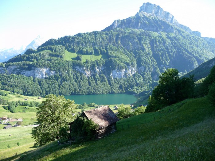 Mountain lake with a cabin and a large mountain