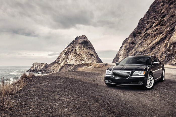 Black Chrysler 300 parked on a coastal road
