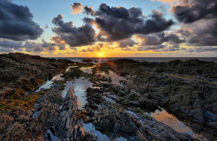 Rocky coastline at sunset with dramatic clouds