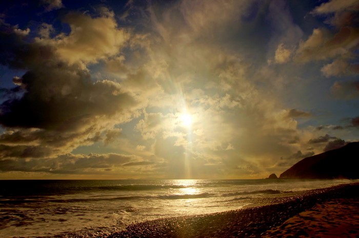 Sunset over the ocean coast with clouds