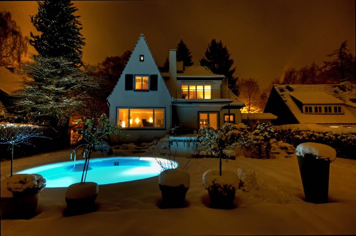 House with a pool at night in the snow