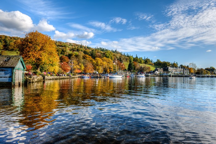 Boathouse on a lake with autumn trees and boats