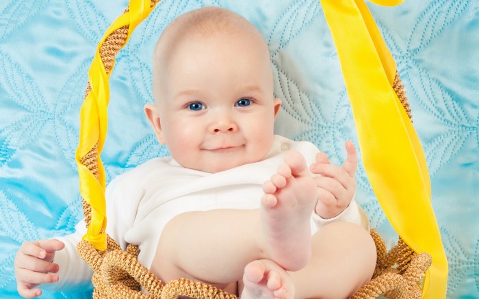 Baby in a basket with yellow ribbon