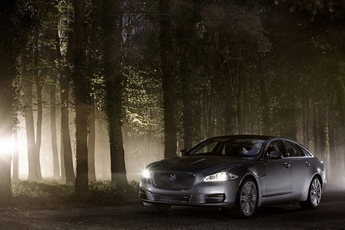 Jaguar XJ sedan parked in a foggy forest at night