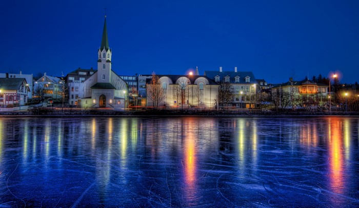 Cityscape with church reflected in frozen lake at night