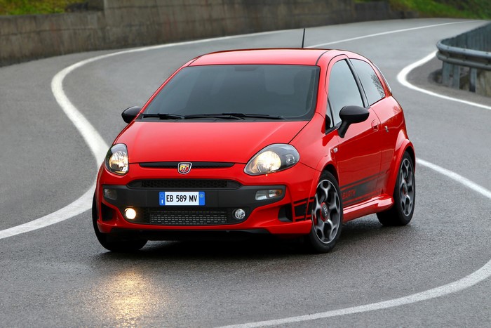 Red Abarth Punto Evo driving on a wet road