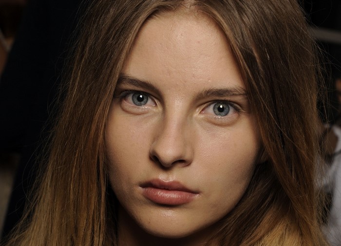 Close-up of a young woman's face with blue eyes and brown hair