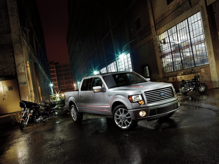 Silver Ford F-150 and motorcycles at night