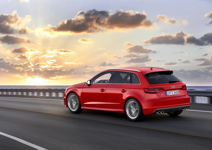 Red Audi A3 Sportback driving on a road at sunset