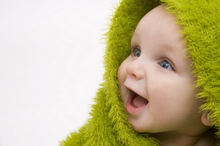 Baby wearing a green fuzzy hood