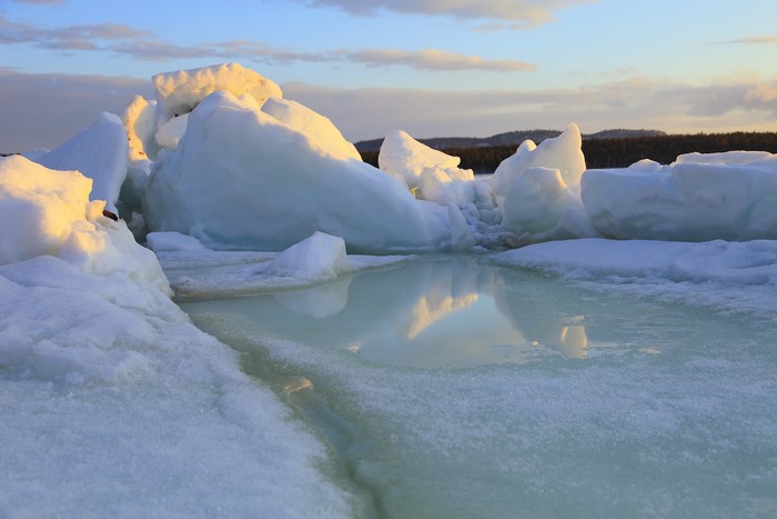 Ice formations on water during sunset