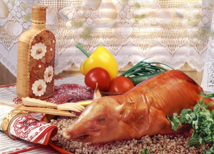 Roasted pig with vegetables and a bottle