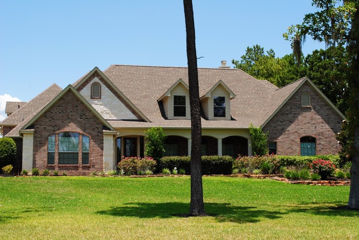 Brick and stone house with a large green lawn