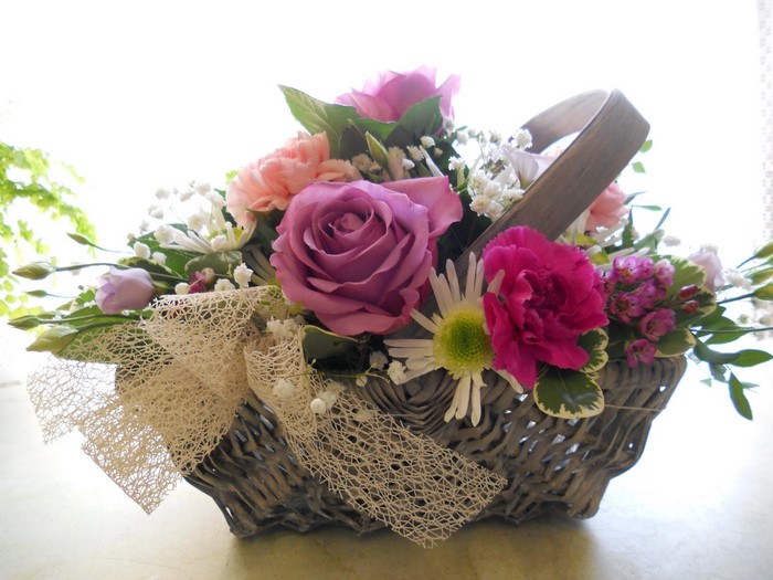 Flower arrangement in a wicker basket with a bow