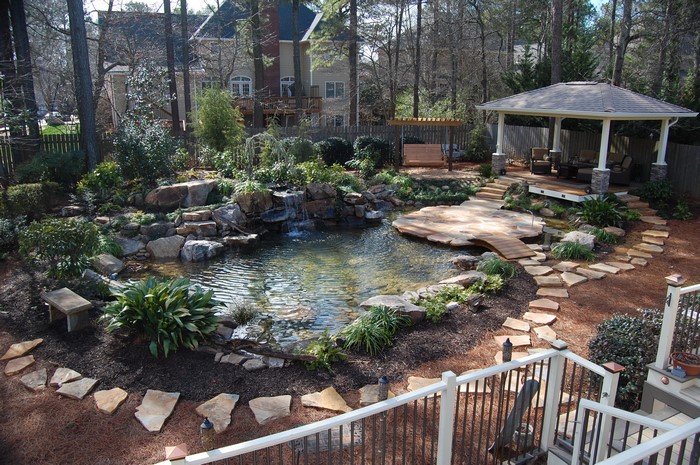 Backyard pond with waterfall, gazebo, and wooden swing